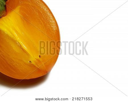 Persimmon. Ripe juicy half a piece of fruit. The cut is juicy with the glitter of juice. Orange color. Green tail. Background isolated white. Dark shadow. Food for health.