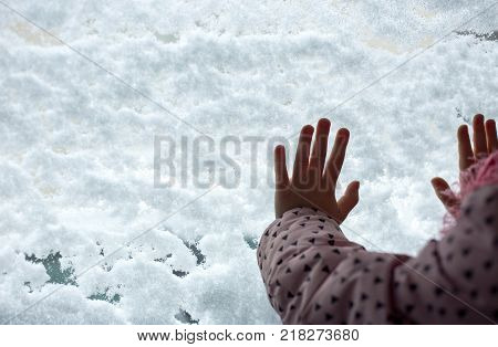 children's hands on snow-covered glass. trace of hands on snow glass