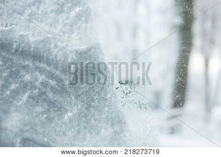 snow-covered window after a snowfall. cleaning the car window after snow