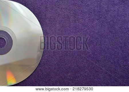Half the CD DVD Bluray on the background of purple fabric and space for text.