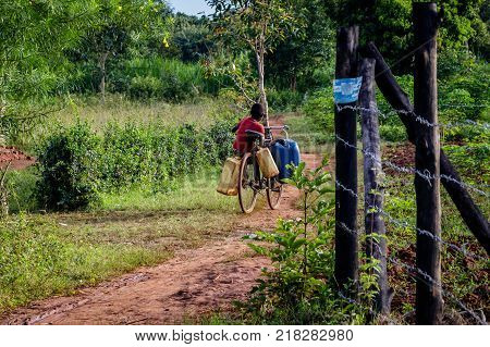 A young boy going to get some water from a nearby well.
