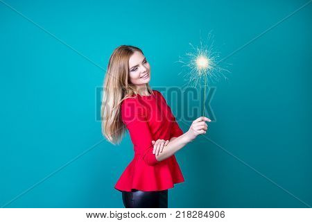 beautiful girl with a bengal fire on a bright background a new year gift sparkler