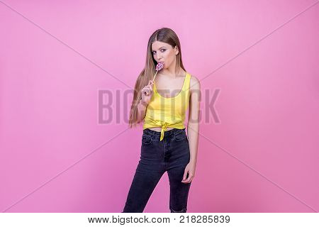bright beautiful girl model with sweet candy on bright holiday background