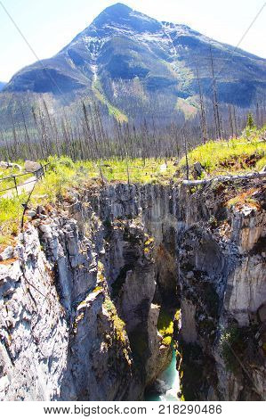 Magnificent gorge at Marble Canyon with Vermilion Peak in the background and turquoise waters flowing from Tokumm Creek beneath. Kootenay National Park British Columbia Canada near Banff. Vertical orientation.