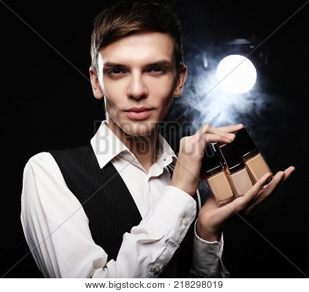  Young male make up artist posing  with foundation for make-up o