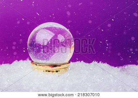 Beautiful snow ball on snowy background over Ultra Violet backdrop.