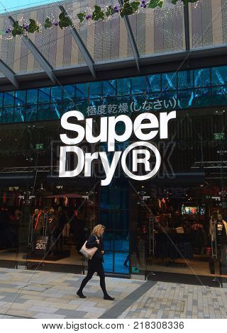 Bracknell, England - Nov 21, 2017: Pedestrian walking by the window display of the Superdry clothing store in Bracknell, England. Superdry is part of Supergroup PLC, a British clothing company