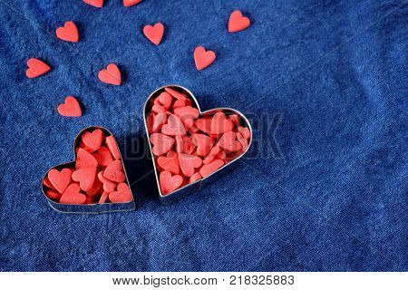 Many little hearts are forming two big ones on a blue background