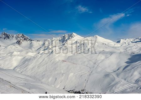 Alpine winter mountain landscape. French Alps covered with snow in sunny day. Val-d'Isere, France