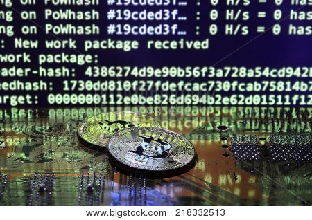 The digital process of cryptocurrency mining by using the GPUs. Bitcoins and video card on a working display and mining screen