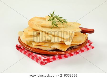 pieces of traditional Tuscan flatbread (Ghiottina Toscana) and kitchen knife on brown plate