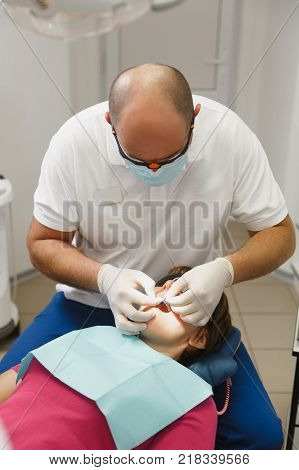 Close Up Process Of Preparing And Installing Dental Ceramic Crown. Male Professional Dentist Helps T