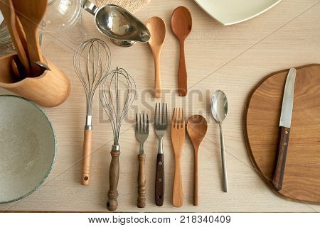 Wooden and metal cultery on the table, view from above