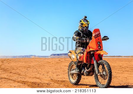 Ait Saoun Morocco - February 22 2016: Unidentified man in helmet riding bike in Ait Saoun desert of Morocco.