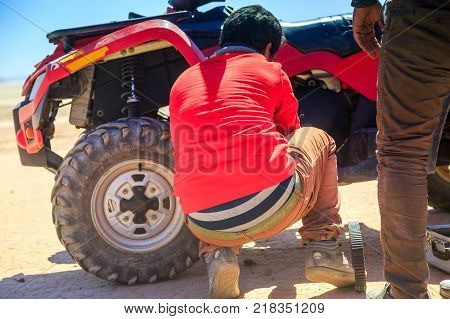 Ait Saoun Morocco - February 22 2016: Man repairing desert buggy car RZR800 in Ait Saoun desert in Morocco to enjoy further drive.
