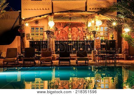 M'hamid Morocco - February 22 2016: view of pool bar in Chez le Pacha hotel with typical decoration with reflection in the pool in front