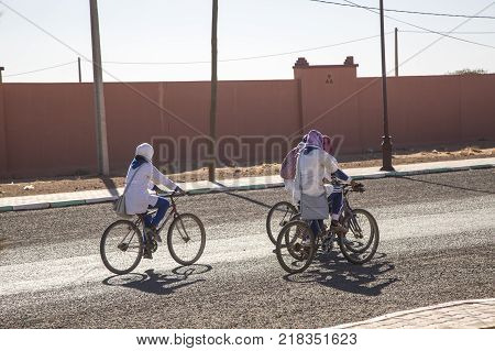 Ait Saoun Morocco - February 23 2016: Woman riding bicycle on a sunny morning in a Ait Saoun village in southern Morocco.