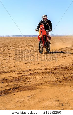 Ait Saoun Morocco - February 22 2016: Unidentified man in helmet riding bike in Ait Saoun desert of Morocco.