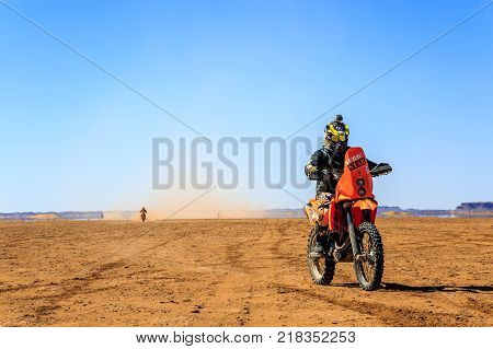 Ait Saoun Morocco - February 22 2016: Unidentified man in helmet riding bike in Ait Saoun desert of Morocco.