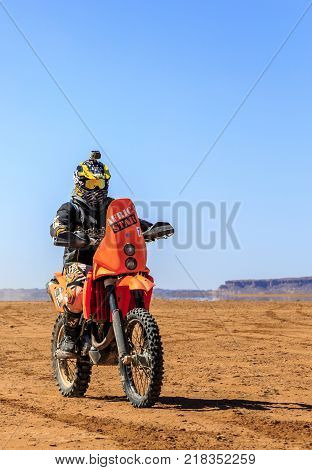 Ait Saoun Morocco - February 22 2016: Unidentified man in helmet riding bike in Ait Saoun desert of Morocco.