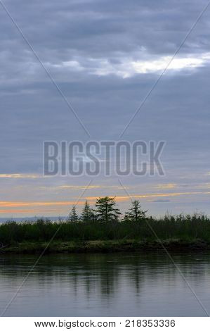 Summer sunset on a Siberian river in the Arctic. Polar day at night on the Taimyr Peninsula. The River Heta Siberia Russia