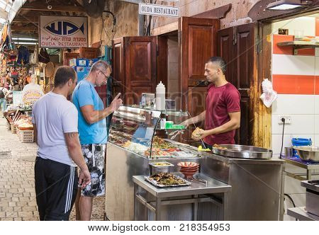 Acre Israel November 03 2017 : The seller sells the clients to the shawarma on the market in the old town of Acre in Israel