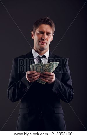 Picture of man in suit counting dollars