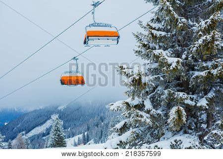 Chair lift with skiers at Alps ski resort