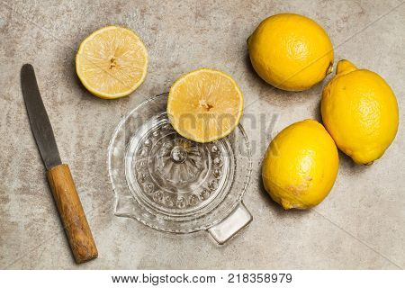 Lemons and glass squeezer on marble table
