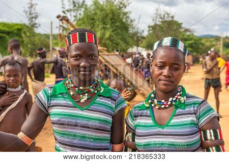 TURMI, OMO VALLEY, ETHIOPIA - MAY 5, 2015: Two girls from the Hamar tribe with traditional jewelry at a popular local market.