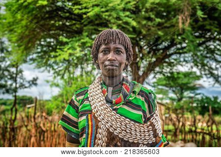 TURMI, OMO VALLEY, ETHIOPIA - MAY 5, 2015: Portrait of a woman from the Hamar tribe in south Ethiopia. Married hamar women apply red clay to their hair and fashion it into long tufts.