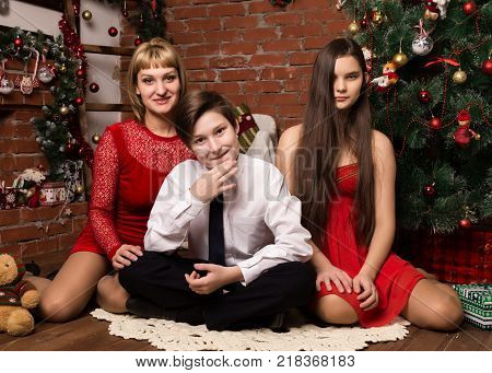 happy family, mother with two children next to cristmas tree in Christmas day.