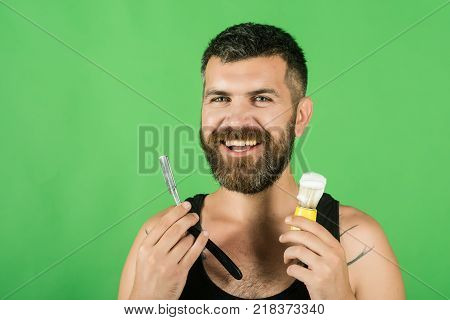 happy hipster in barbershop new technology. Haircut of bearded man archaism. Fashion and beauty innovation. Barber and hairdresser. Man cut beard and mustache with razor and shaving brush.