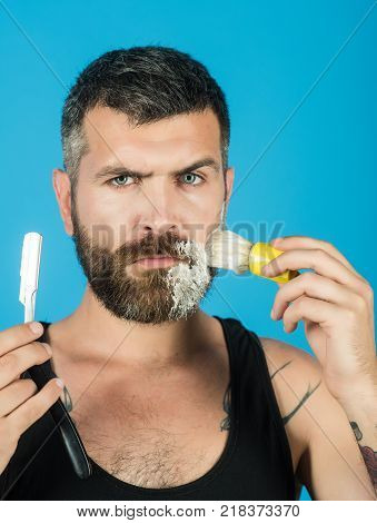 happy hipster in barbershop new technology. Haircut of bearded man archaism. Fashion and beauty innovation. Barber and hairdresser. Man cut beard and mustache with razor and shaving brush.