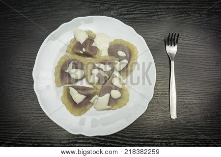 Top view of a plate with dumplings filled with cottage quark and blueberry.