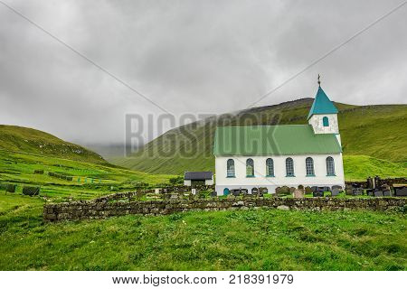 Small church with cemetery in the village of Gjogv located on the northeast tip of the island of Eysturoy, Faroe Islands, Denmark