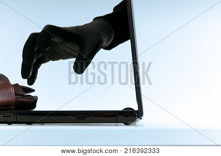 Conceptual internet crime image, human hand in gloves trying to reach the walet