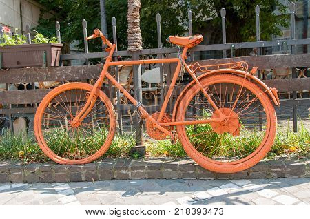 Orange, vintage bicycle on the road side