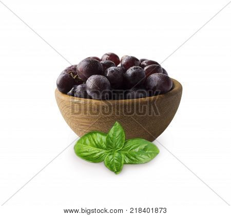 Grapes ith basil in a wooden bowl isolated on white background. Purple grapes with copy space for text. egetarian or healthy eating.