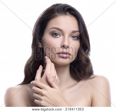 Beauty SPA woman with perfect skin portrait. Gorgeous brunette touching cheek. SPA beauty, facial treatment and cosmetology concept. Isolated on white.