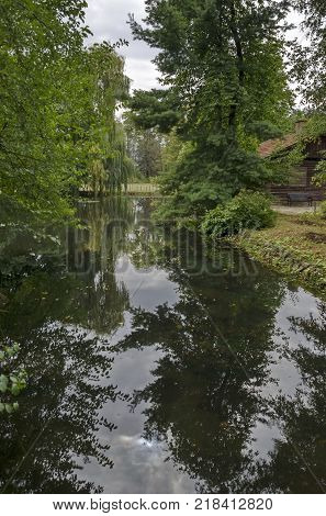 Forest and lake with reflection in National monument of landscape architecture Park museum Vrana in former time royal palace on the outskirts of Sofia, Bulgaria, Europe
