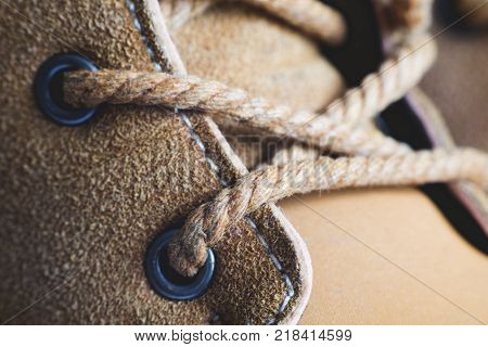 Macro yellow suede boots shoes and shoelaces on wooden background. Autumn or winter shoes. Macro