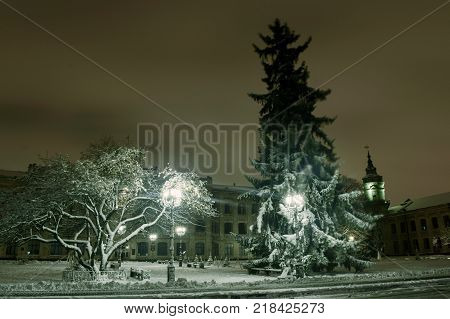 Snowy evening landscape of the city square.
