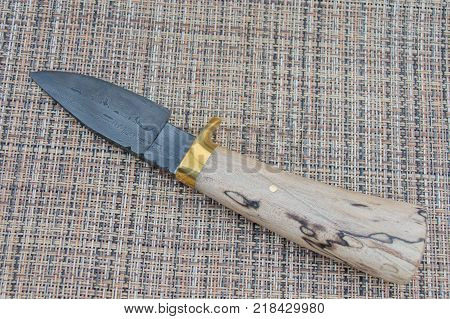 A Damascus hunter knife with stabilized spaulted maple handle.