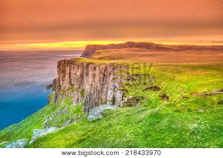 Sunset at Waterstein Head coastline, hiking path for visiting the top of three great coastal cliffs. Duirinish coast, Isle of Skye island, Highlands of Scotland in United Kingdom.