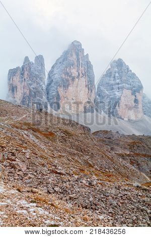 Tre Cime di Lavaredo in beautiful surroundings in the Dolomites at foggy weather in Italy Europe (Drei Zinnen)