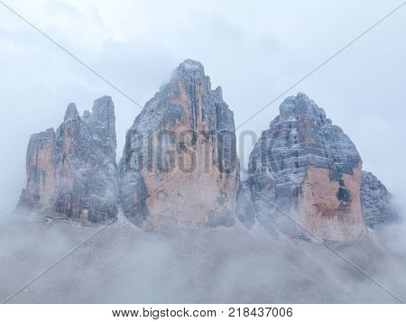 Tre Cime di Lavaredo in beautiful surroundings in the Dolomites at foggy weather in Italy Europe (Drei Zinnen)