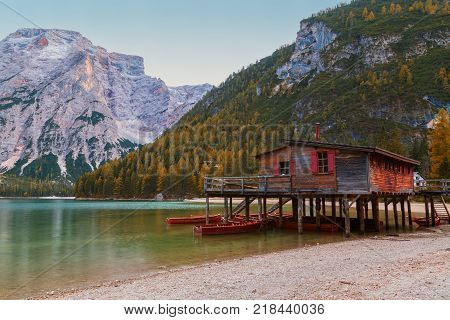 Old wooden house on the Braies lake in the background of Seekofel mountain in DolomitesItaly ( Pragser Wildsee )