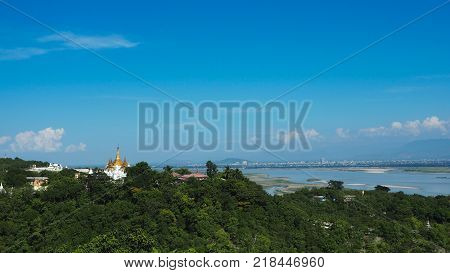 High angle view of multiple temples and pagodas on the mountains with Irrawaddy river in the background from sagaing hill, Sagaing region of Myanmar.
