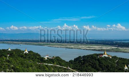 High angle view of multiple temples and pagodas on the mountains with Irrawaddy river in the background from sagaing hill, Sagaing region of Myanmar.